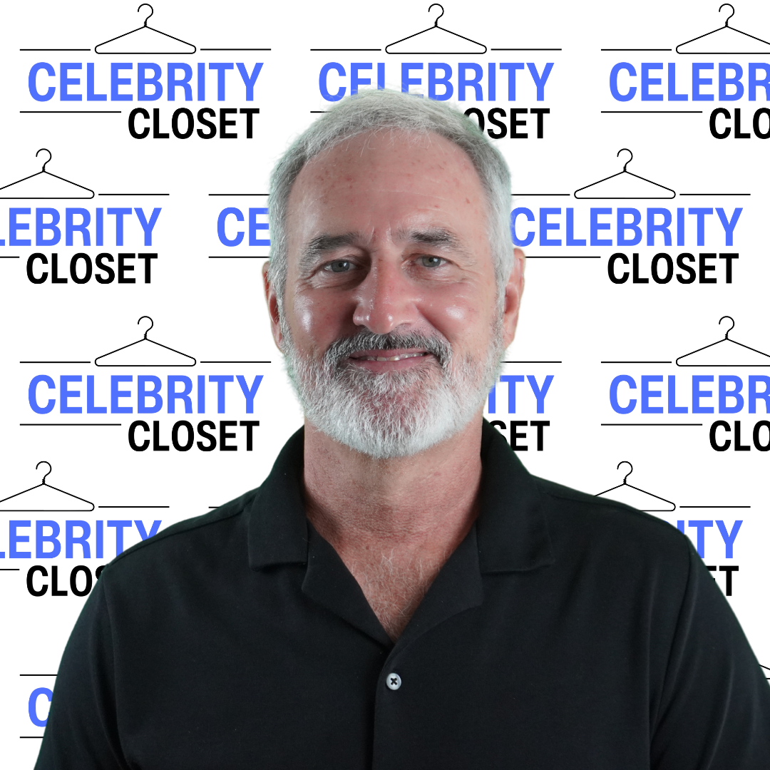 A middle-aged man with gray hair and a beard, wearing a black collared shirt, smiling at the camera with a backdrop of a repeating pattern of the 'Celebrity Closet' logo featuring a black hanger and bold blue and black text.