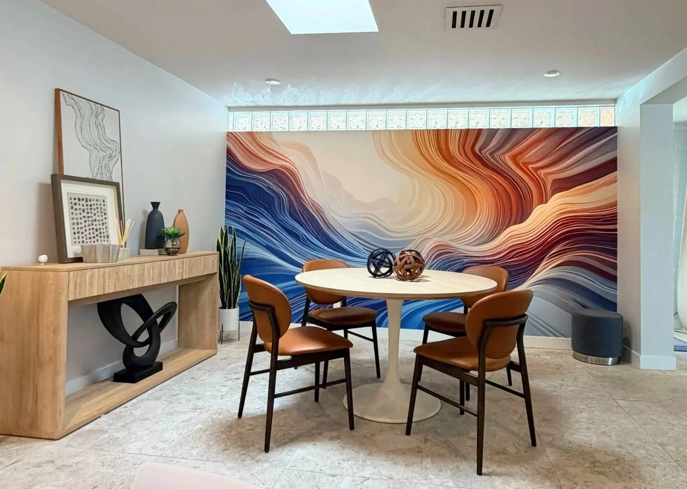 Styled dining and content creation area at Green Orange Studio with colorful mural, wood sideboard, skylight, and modern studio decor.