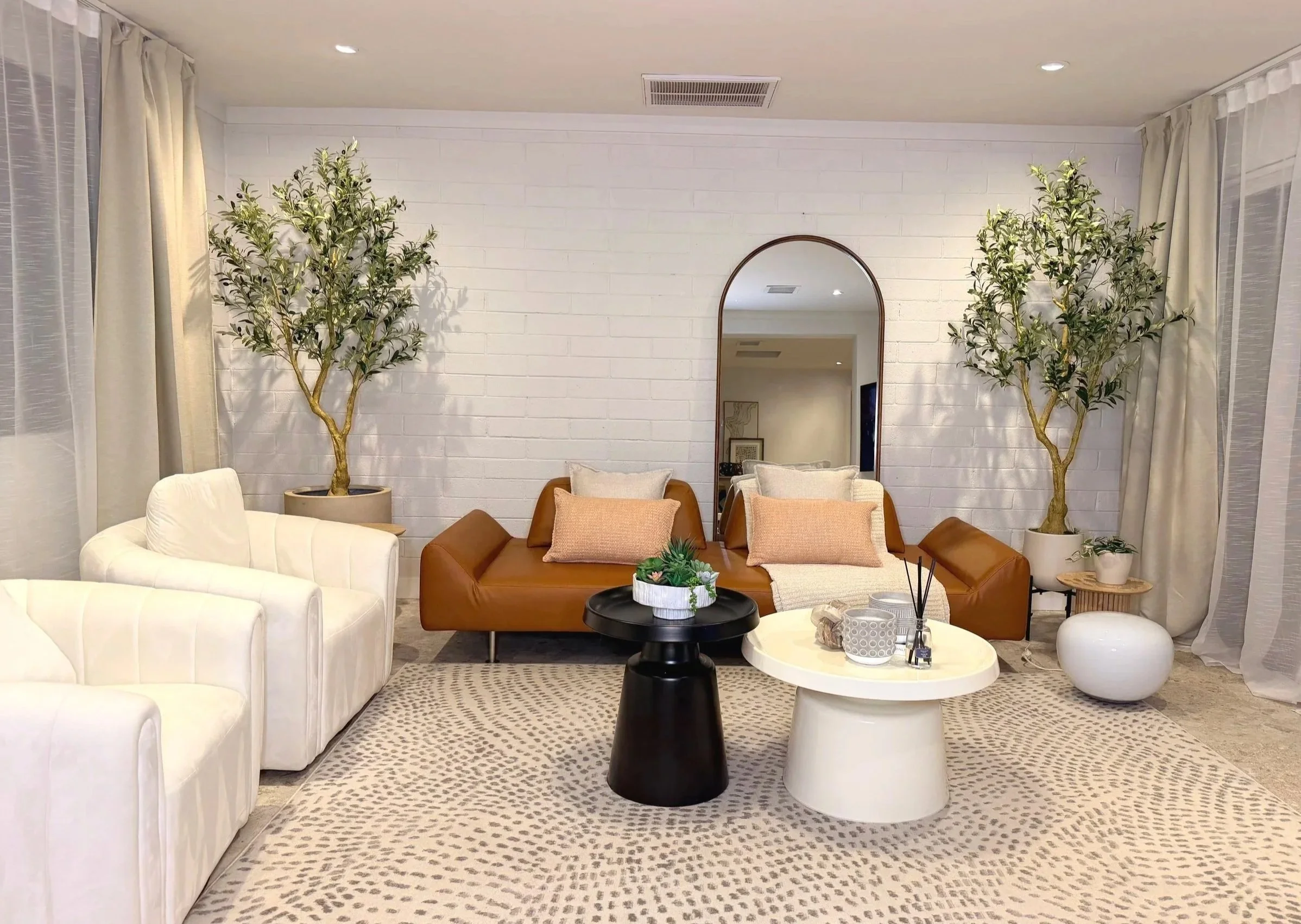Bright North Phoenix creative studio rental with white brick wall, natural light, plants, modern seating, and styled space for photoshoots and content creation.