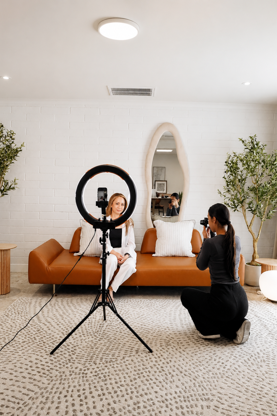 Content creation session at Green Orange Studio with video setup, natural light, mirror, plants, and cozy studio seating for branding or social media content.