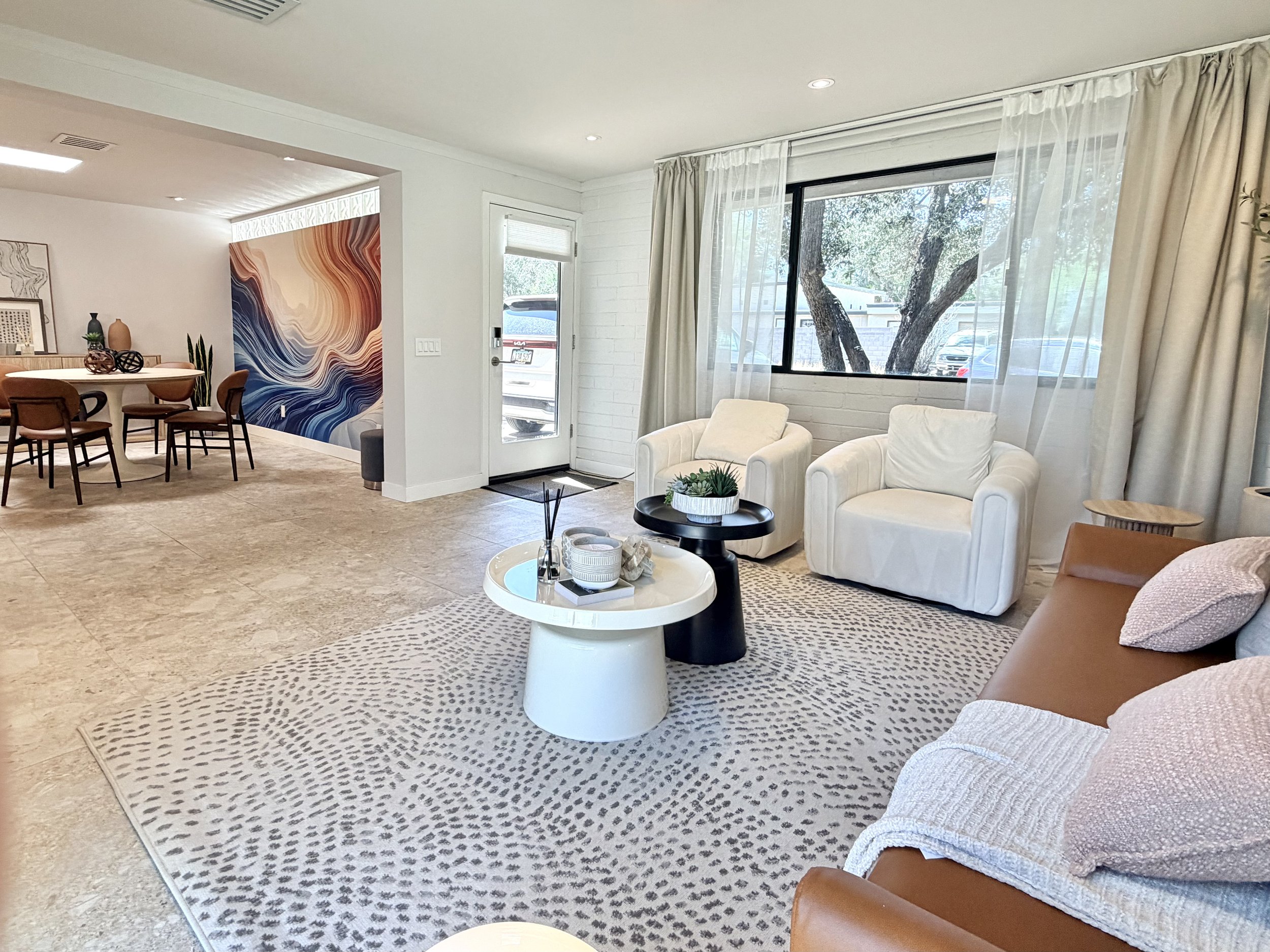 Spacious North Phoenix creative studio with living room seating, dining area, artwork, and flexible space for branding shoots and meetings.