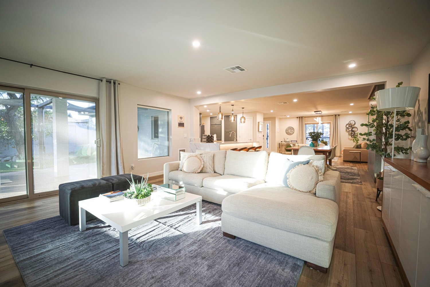 Open great room with sectional seating, large windows and a view through to the kitchen.