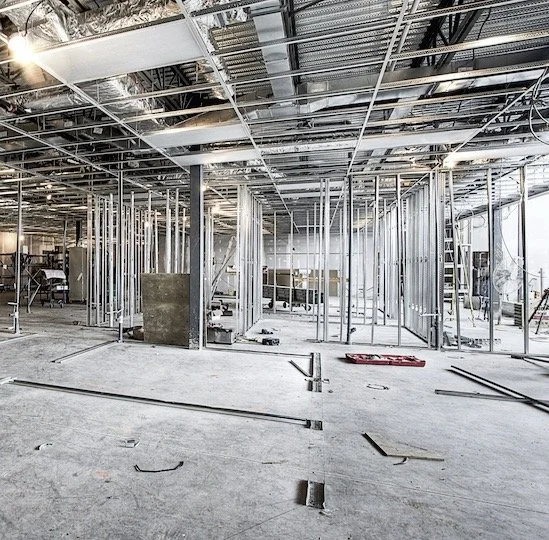 Construction site with metal framing for new walls inside a building.