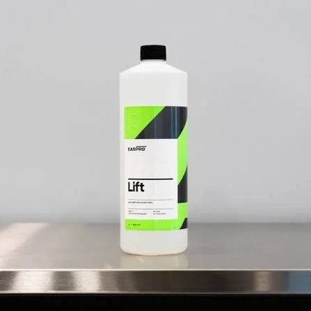 A white plastic bottle with a black cap and a green, black, and white label that reads 'Lift,' placed on a stainless steel surface against a gray background.