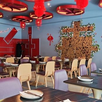 Restaurant decorated with red lanterns, a large paper tree with leaves, and string lights for a festive celebration.