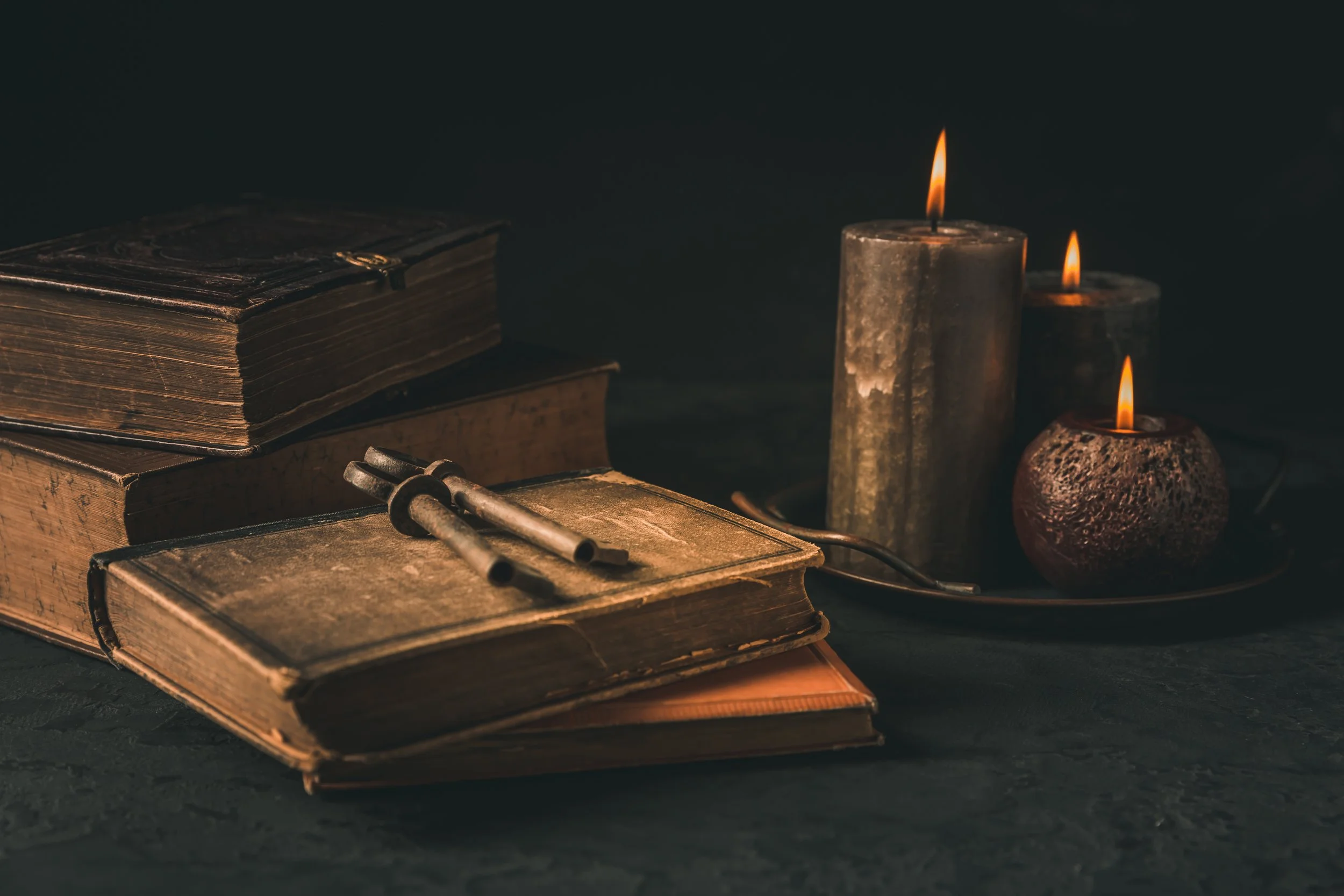 antique-books-and-candles-in-moody-dark-setting-2026-03-16-22-59-51-utc.jpg
