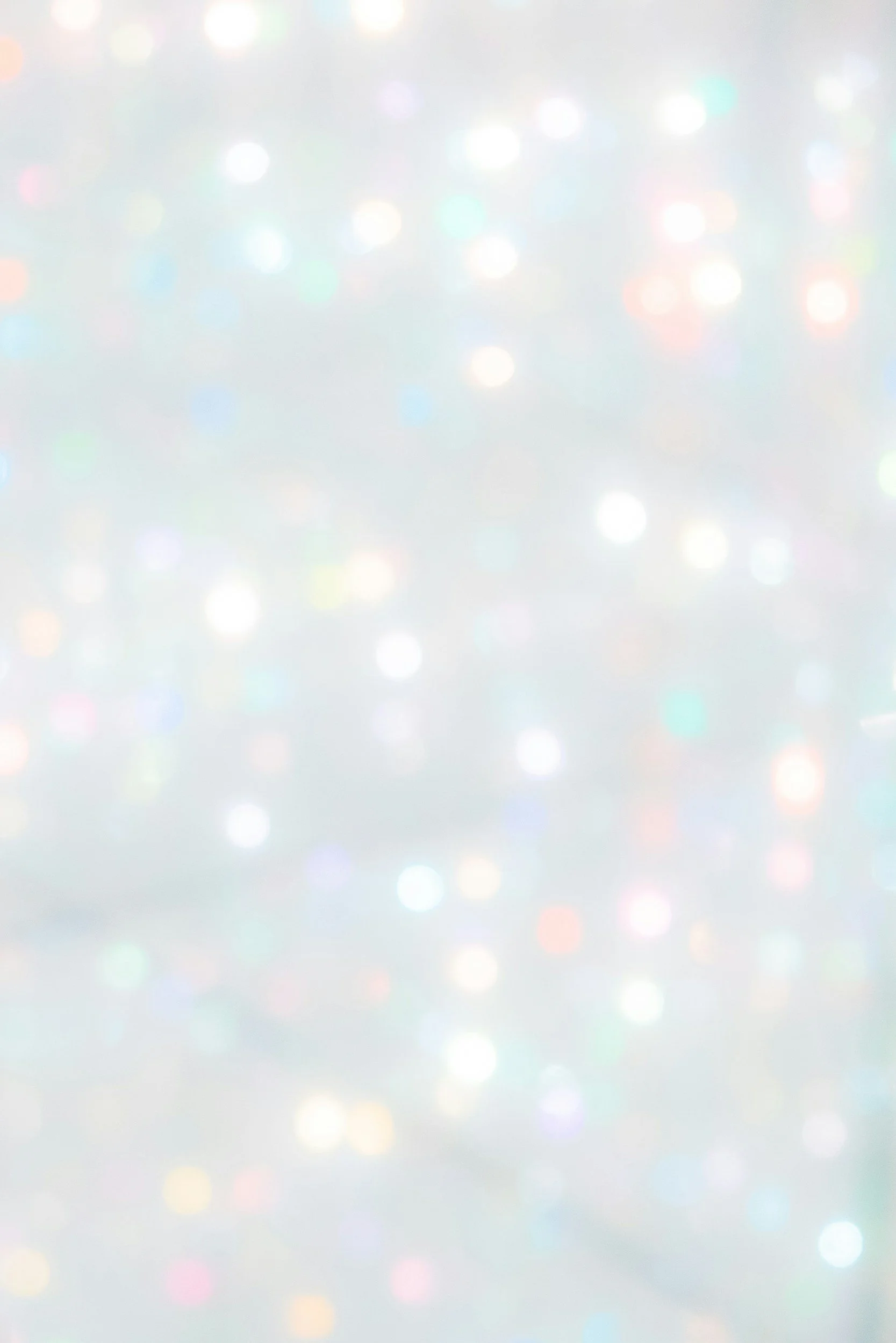 Blurred multicolored lights or bokeh effect against a light background.