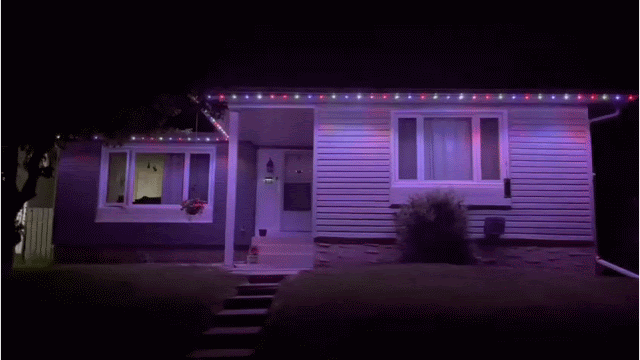 A house decorated with colorful Christmas lights at night.