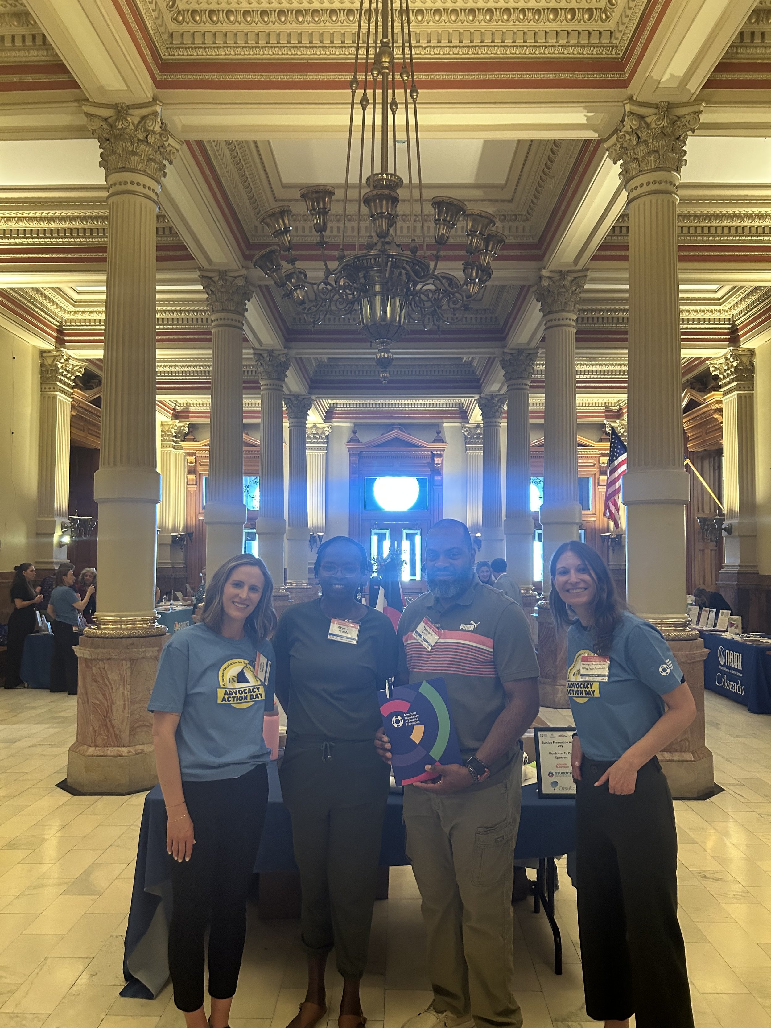 Four community advocates together at a Colorado advocacy event.
