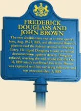 A blue official certificate with gold emblem at the top. The certificate contains text about Frederick Douglass and John Brown, mentioning their historical significance and key dates.