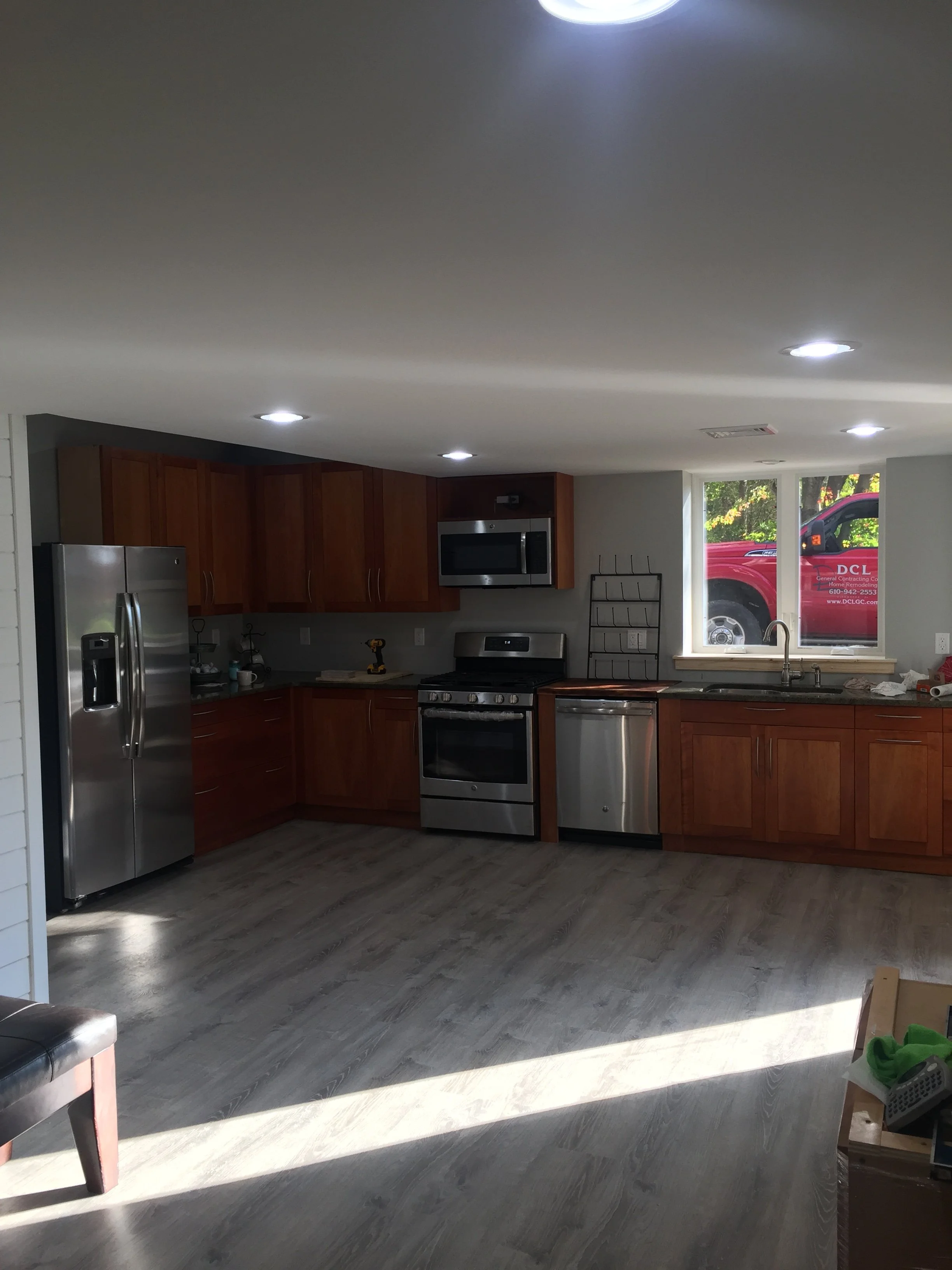Kitchen with wooden cabinets, stainless steel appliances, a window, and natural light streaming in.