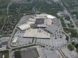 Aerial view of a large shopping mall with parking lots and surrounding roads.
