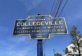 Sign for Collegeville in Portland-ME region, noting colleges located there; blue sky and power lines in background.