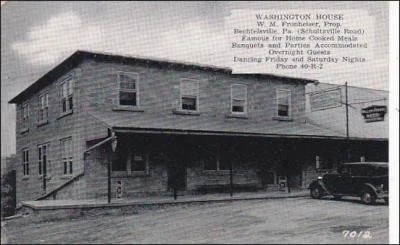 Black and white photo of a two-story building with a sign for the Washington House, a supper club in Bungalow and Parties, with an attached porch and a car parked in front.