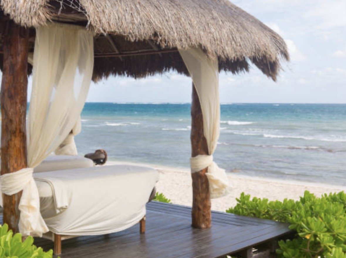 open-air thatched-roof massage hut on white sand beach in Panama