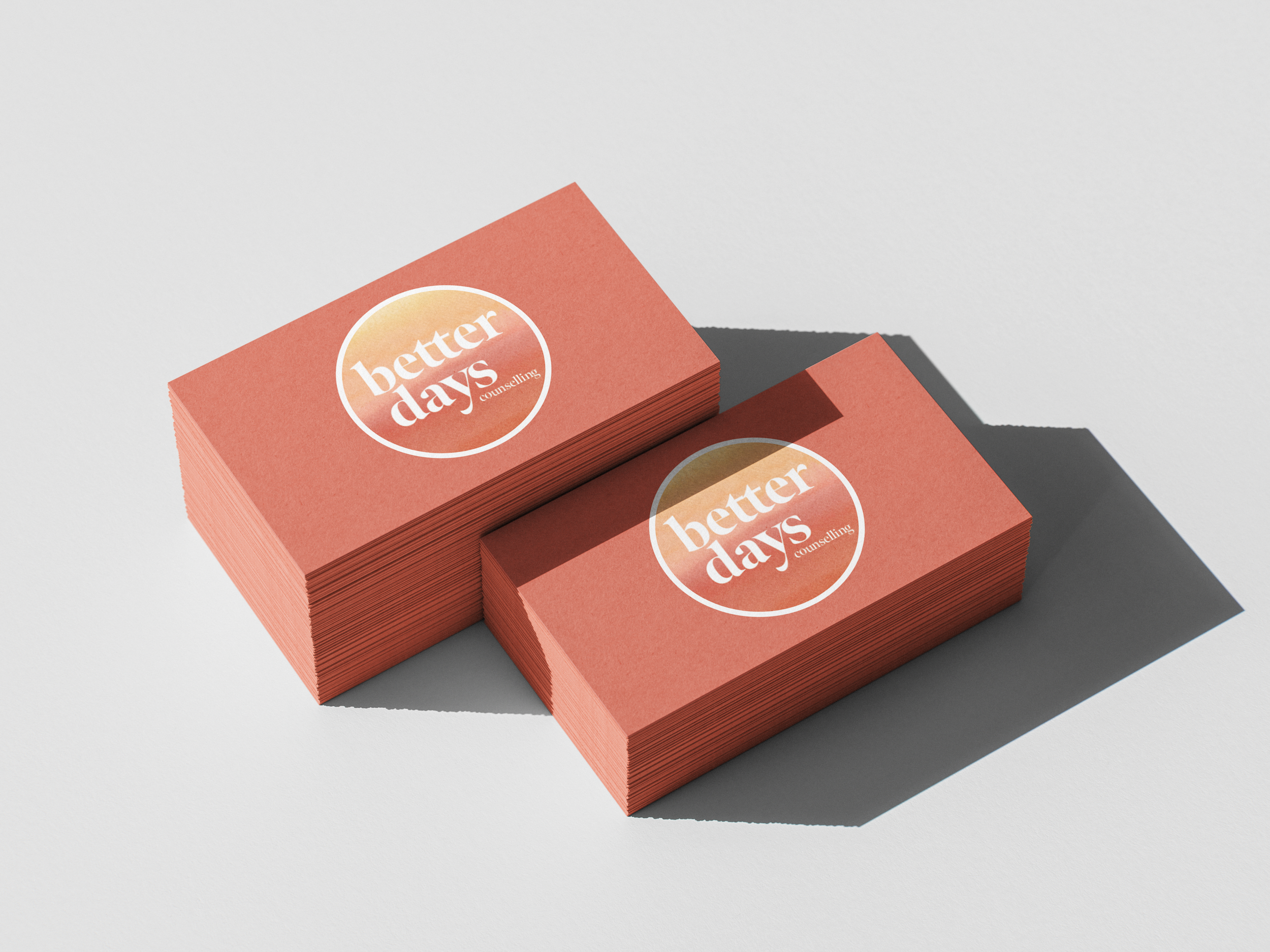 Stack of business cards with a pink background and a circular logo that says "better days counseling" in white text.