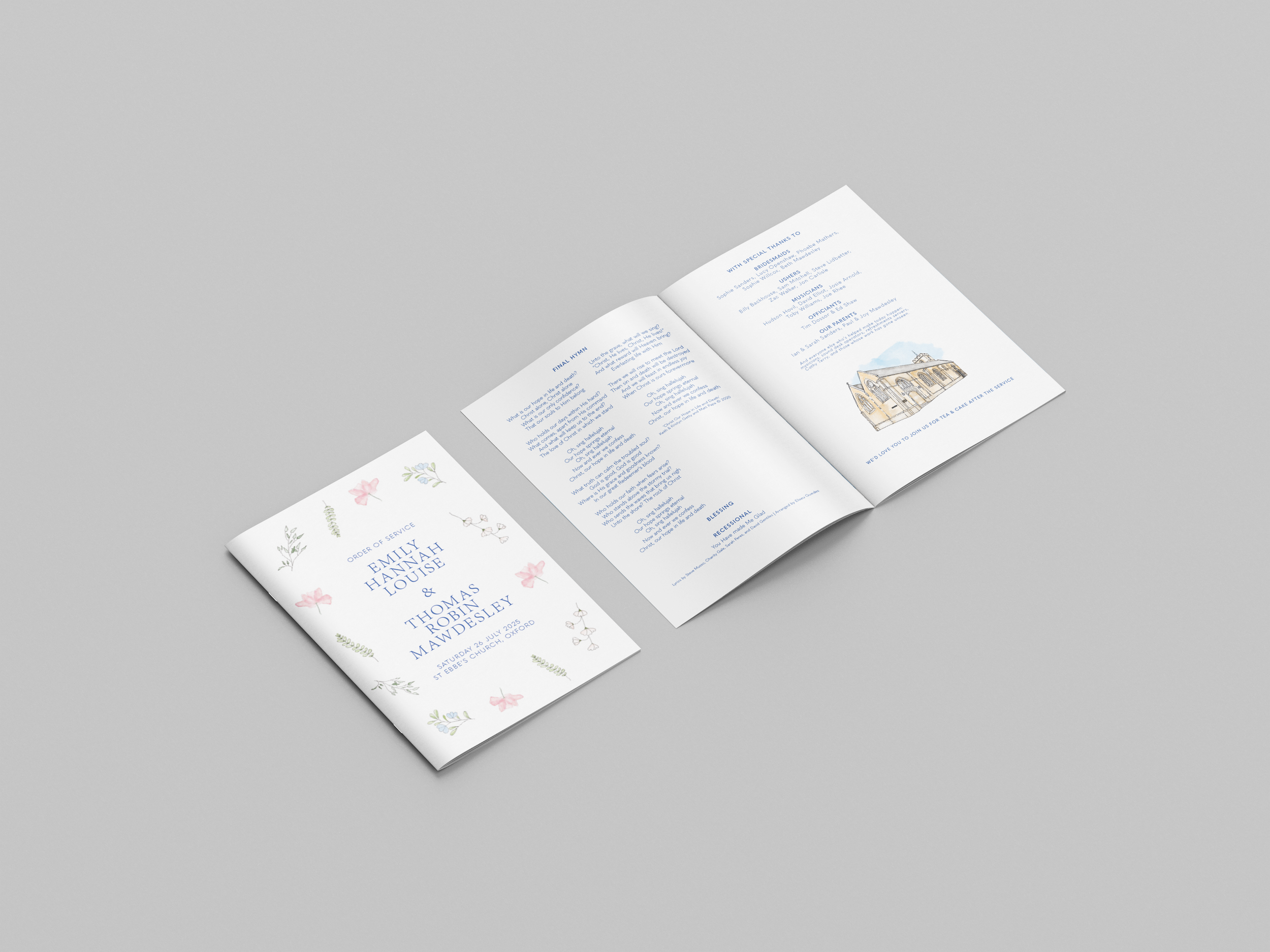 Open wedding program with floral design and blue text on white background, lying on a light gray surface.