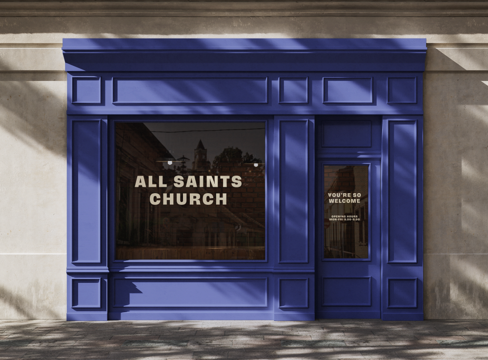 The storefront of All Saints Church with a blue facade, large window, and entrance door, displaying the church name and welcoming message.
