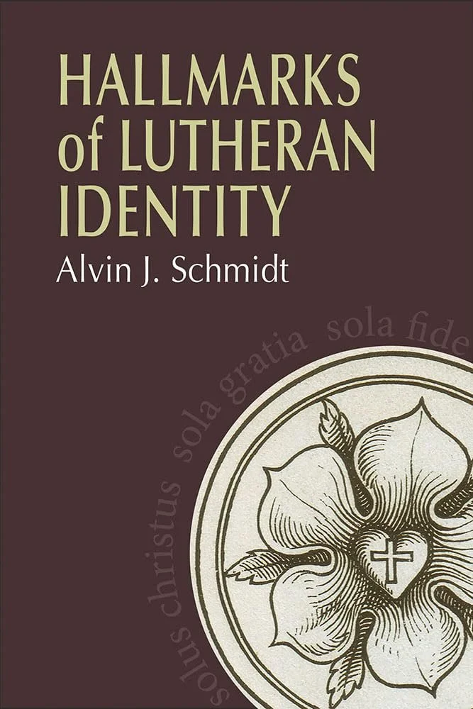 Book cover titled 'Hallmarks of Lutheran Identity' by Alvin J. Schmidt with a circular emblem featuring a flower, a cross inside a heart, and Latin phrases around it.