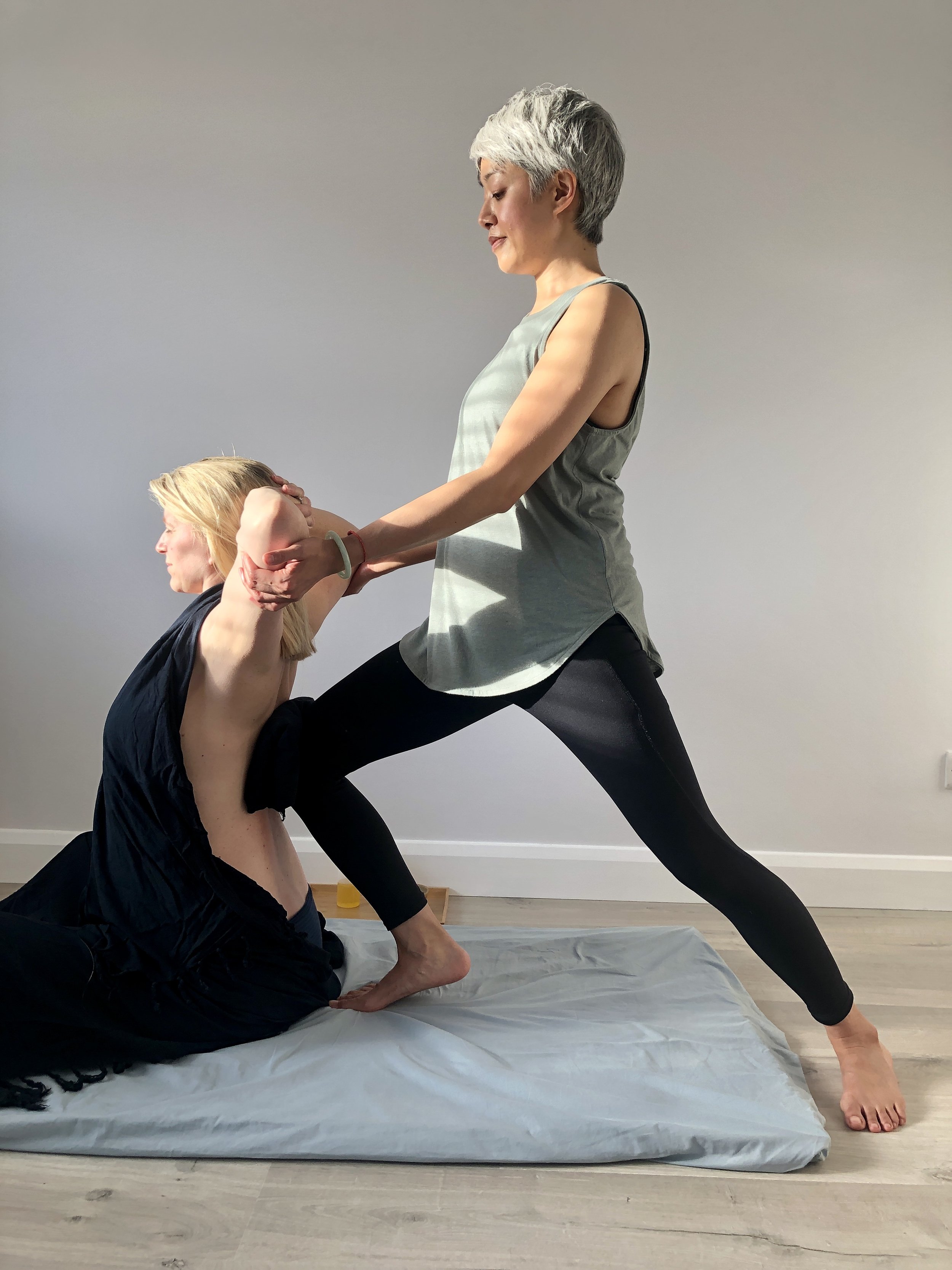 An assisted heart opener seated stretch during an Ayurvedic Yoga Massage with Yoga with Ping.