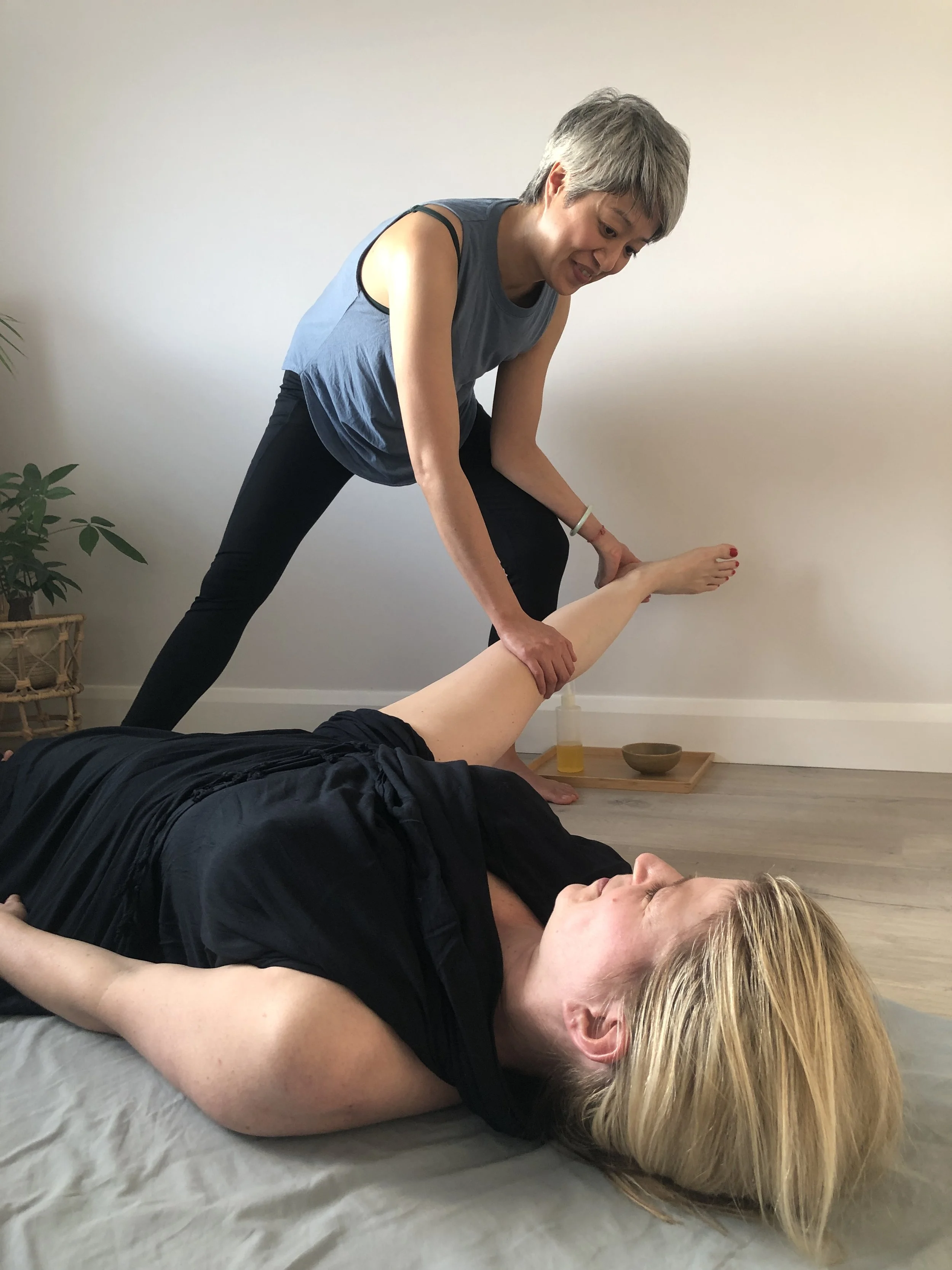 An assisted adductor leg stretch during Ayurvedic Yoga Massage.