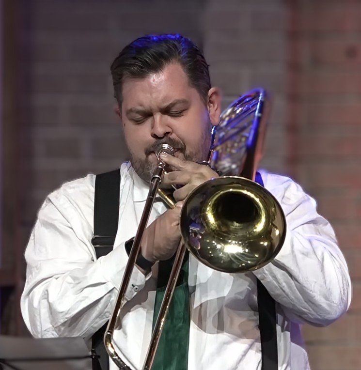 Craig Beattie playing a trombone with signature green tie