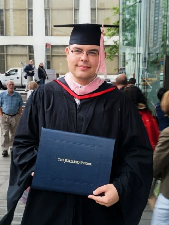 Craig Beattie holding his Juilliard diploma having graduated with a master's degree