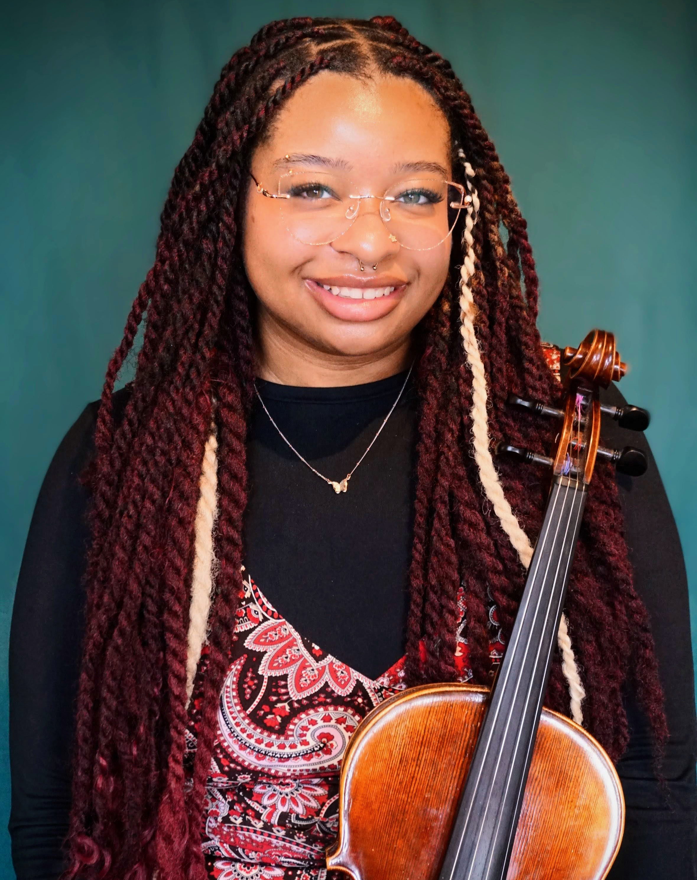 Headshot of smiling female tutor with long braids wearing a lanyard.
