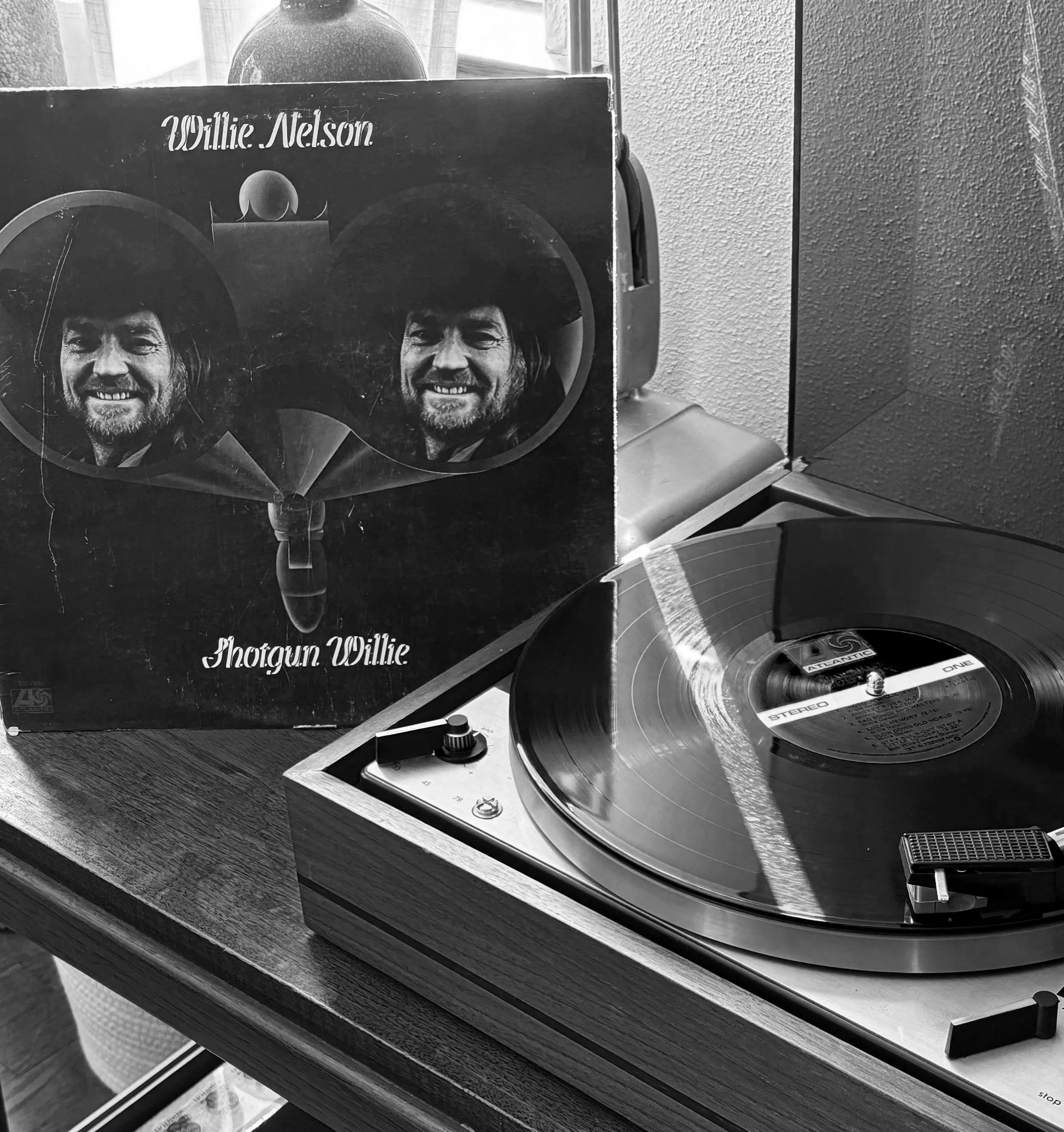 Vintage vinyl record player spinning a Willie Nelson album in the creative studio of Dupuy&Co.