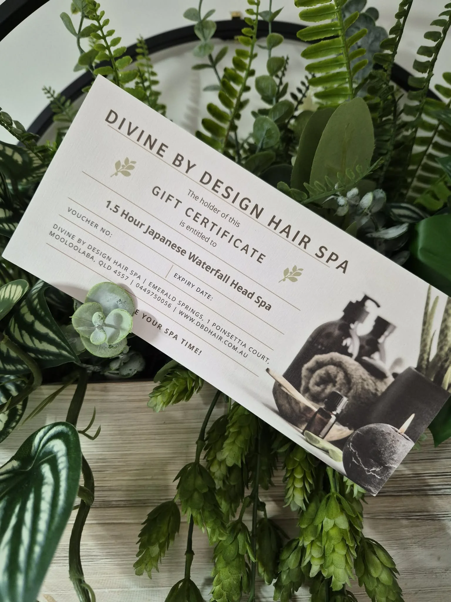 divine by design hair spa gift certificate leaning on silk plants