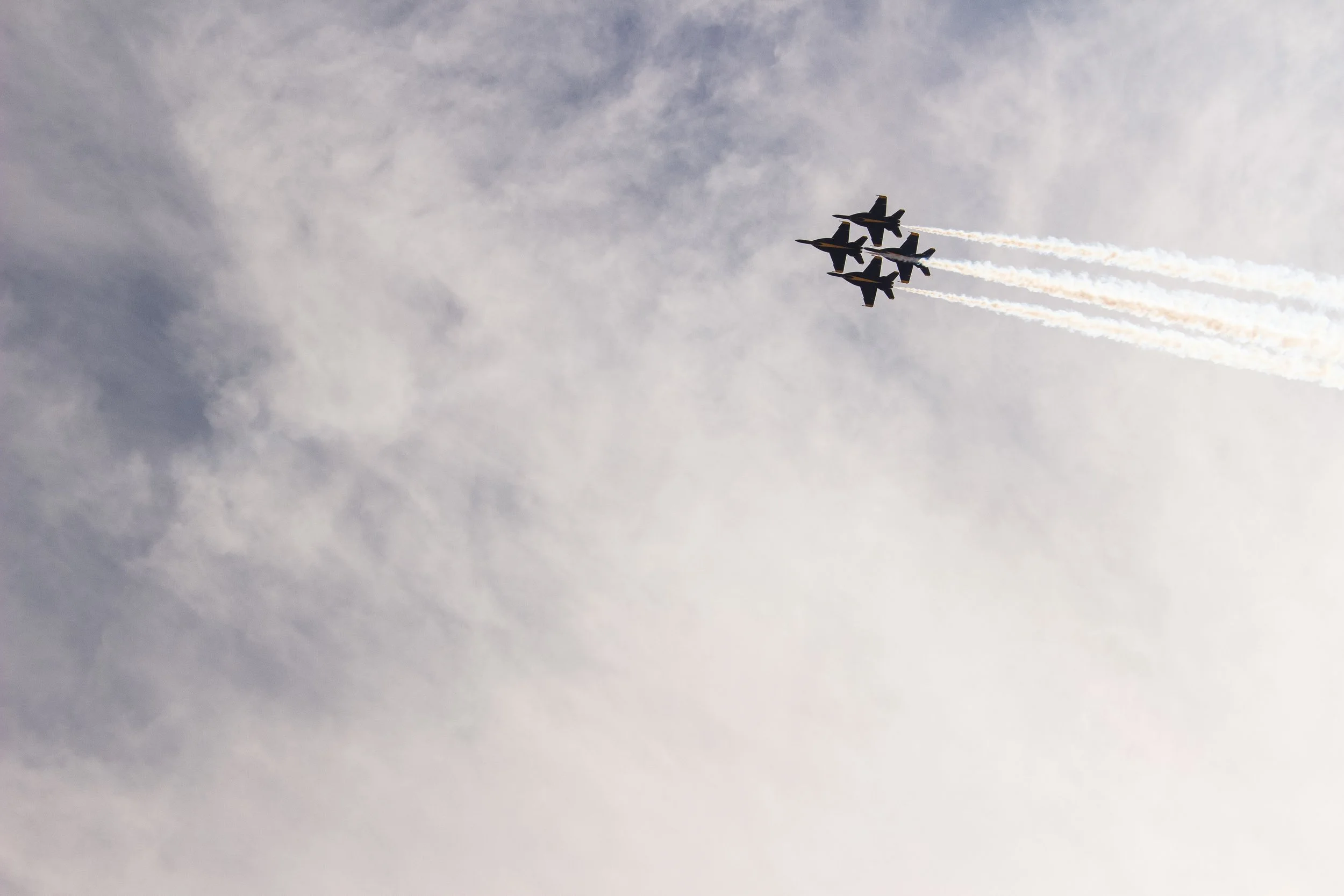Five fighter jets flying in close formation high in the sky, leaving white smoke trails behind.