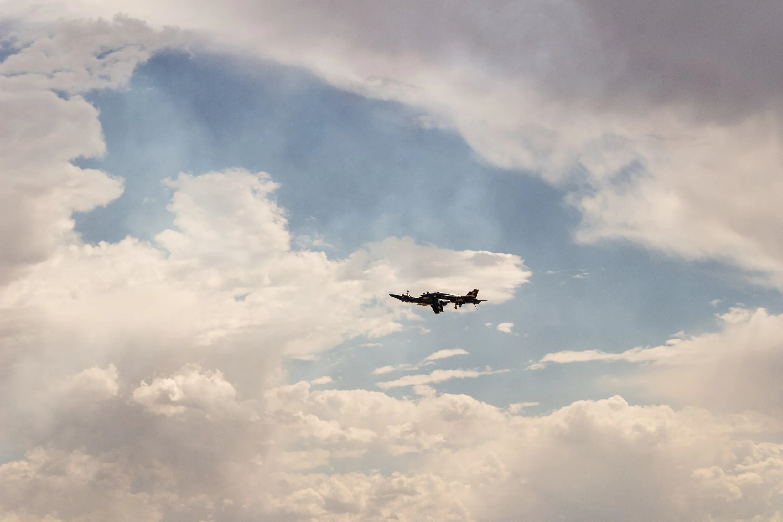 A fighter jet flying in the sky among clouds