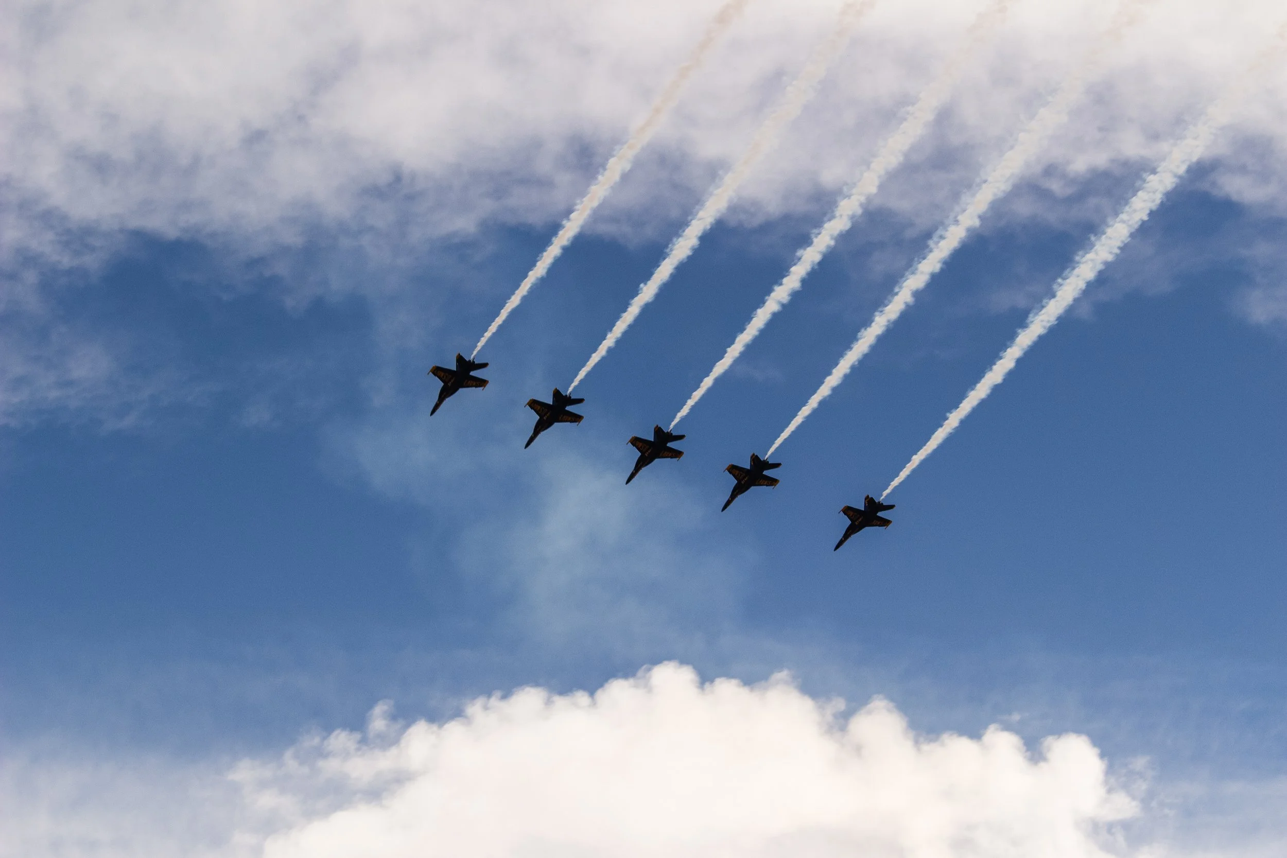 Six fighter jets flying in formation with contrails in the sky.