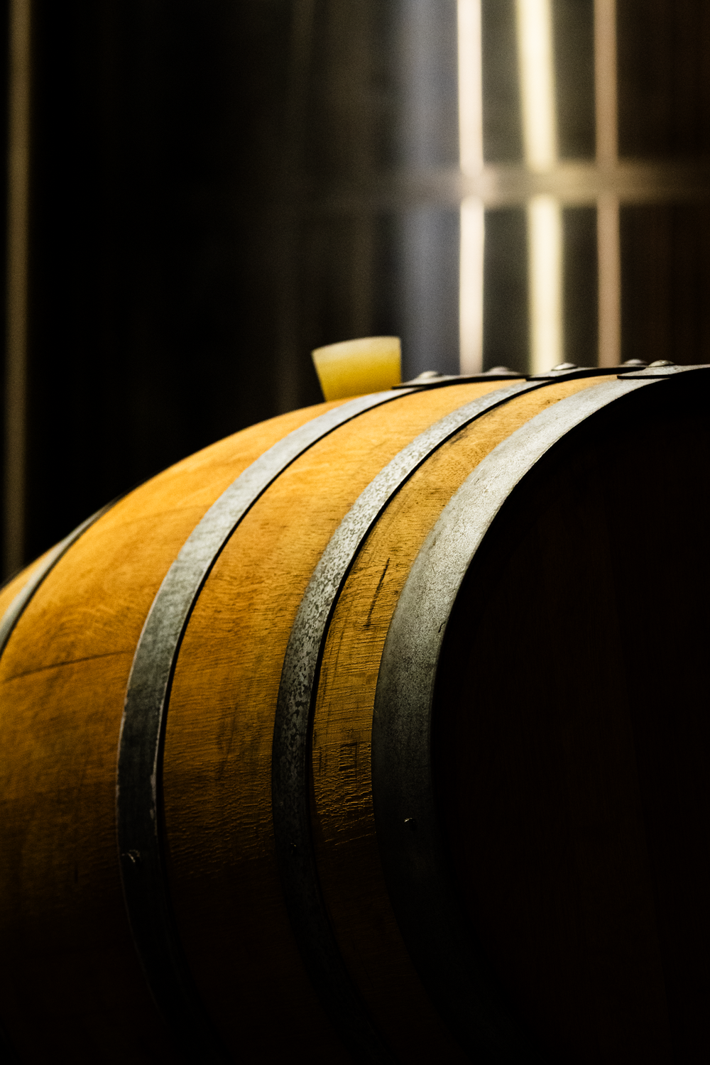 Close-up of a barrel lit gold in the dark