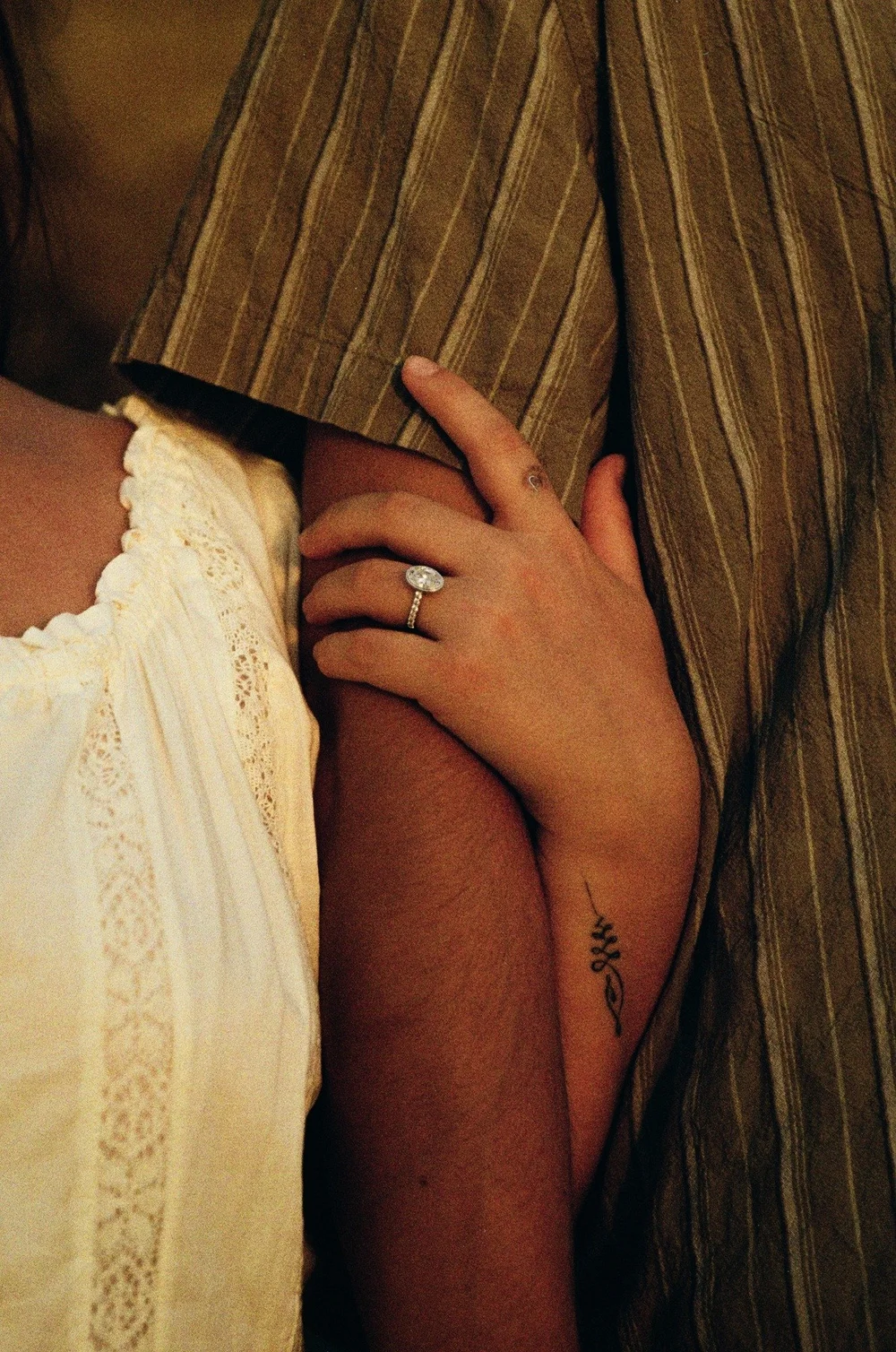 Close-up of Rose's engagement ring as she holds Brady's arm at La Jolla Shores, shot on 35mm film