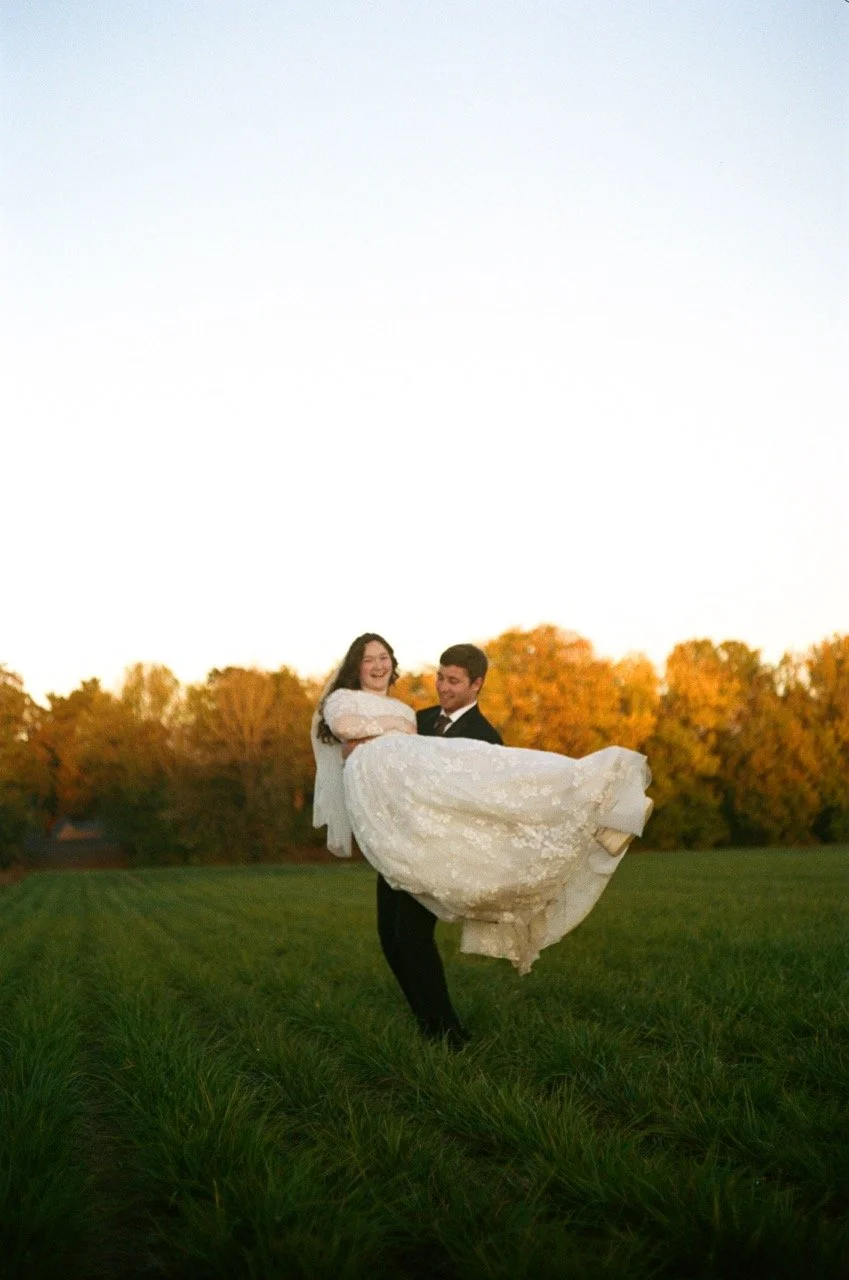 Preston carrying Carley across a green field at sunset, shot on film