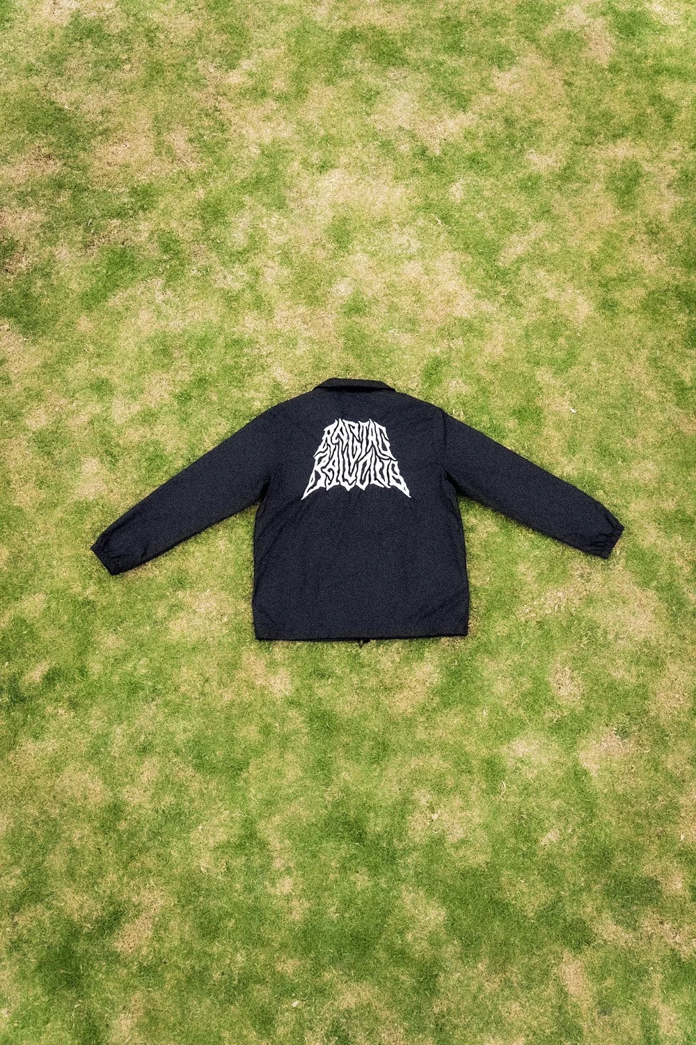 Black Ragtag jacket laid flat on grass