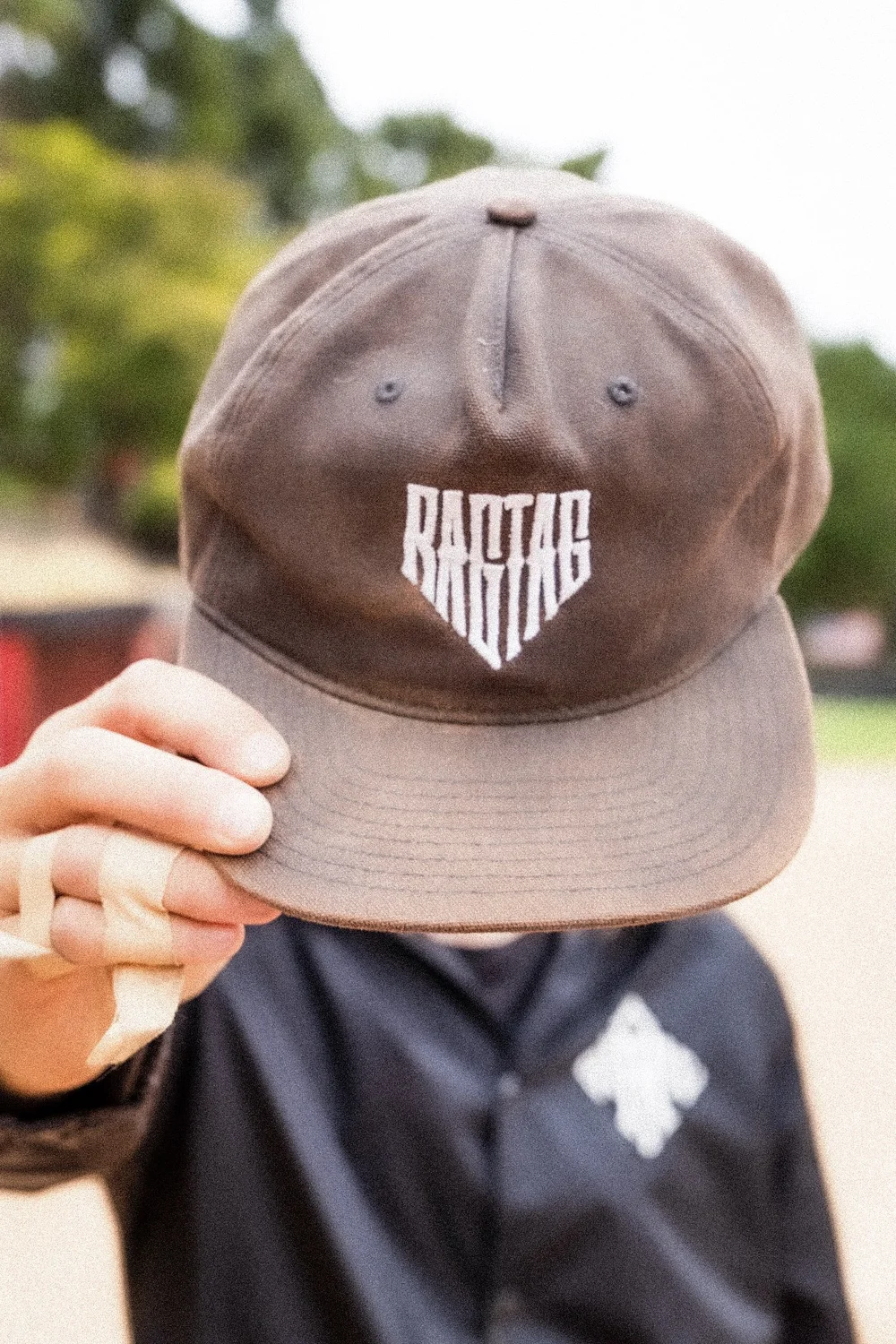 Player tipping a washed brown Ragtag Ballclub cap over his face in San Diego