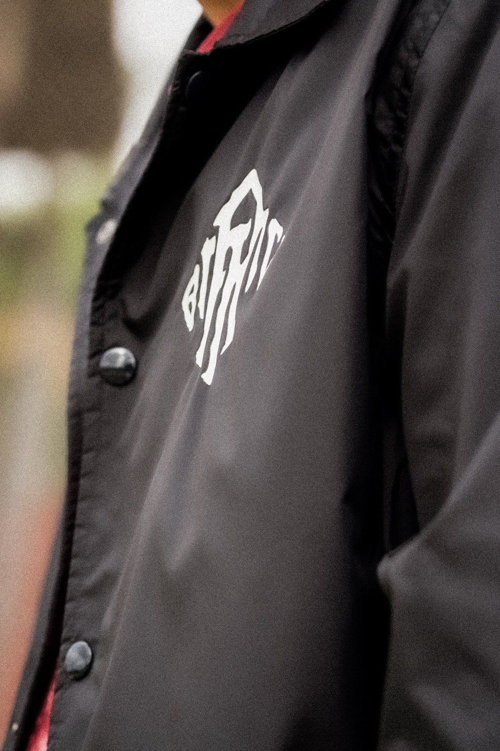 Close-up of the Ragtag logo on a black jacket being worn