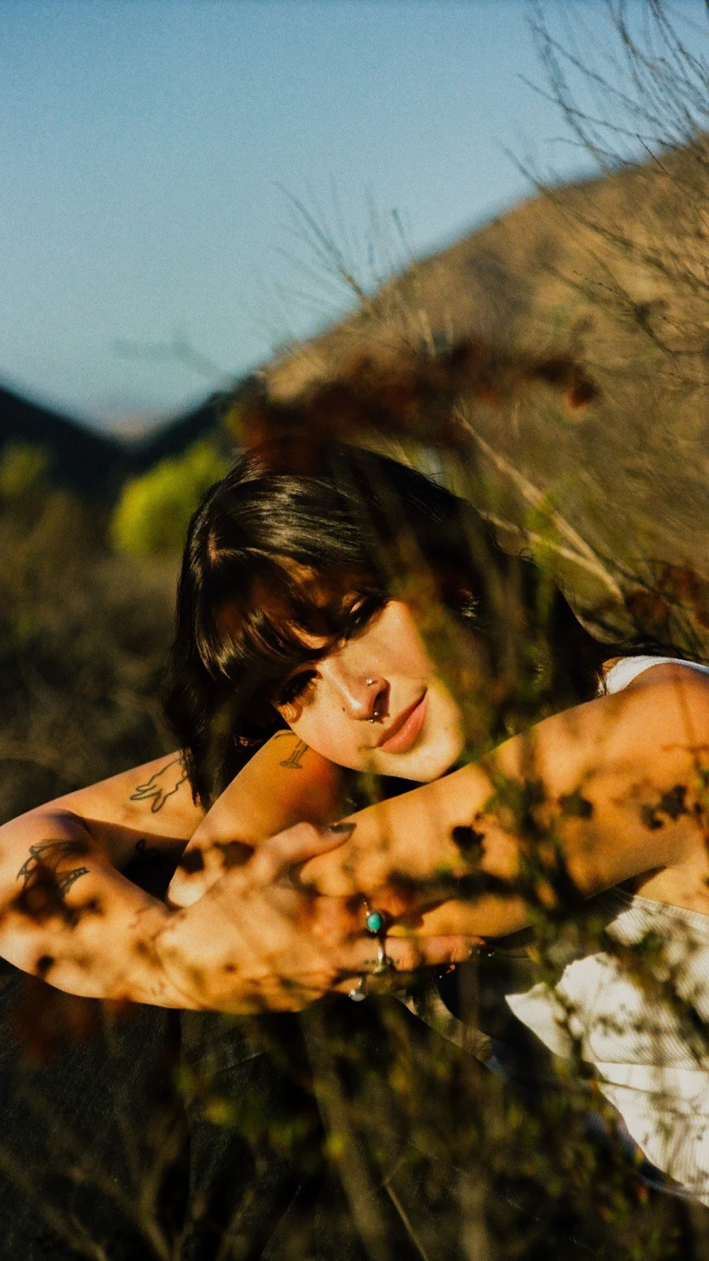 Laurel through the brush, light on her face, in El Cajon, shot on 35mm film