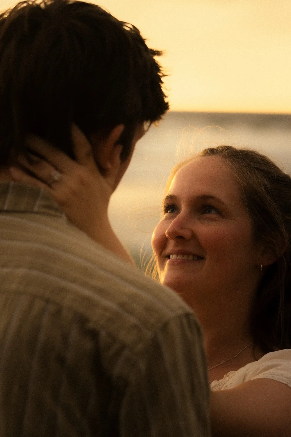 Rose smiling over Brady's shoulder at golden hour at La Jolla Shores