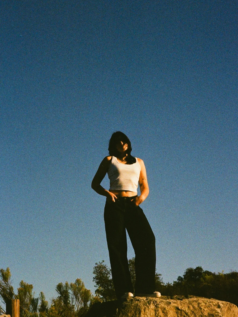 Laurel standing on a rock against a deep blue sky in El Cajon, shot on 35mm film