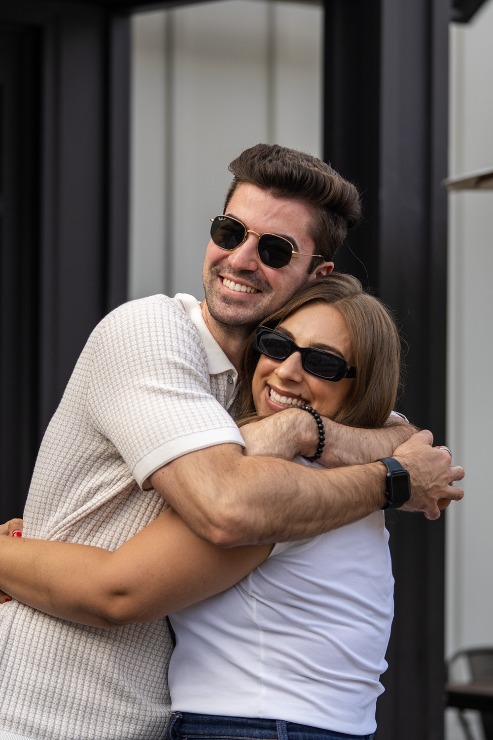 Two guests hugging hello at a Compass Real Estate evening