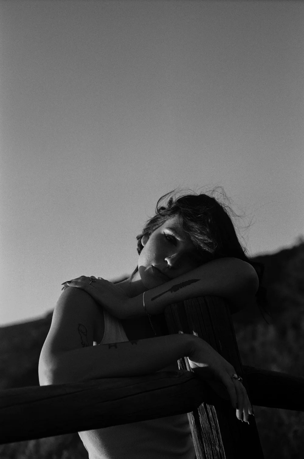 Laurel resting on a fence in black and white in El Cajon, shot on 35mm film