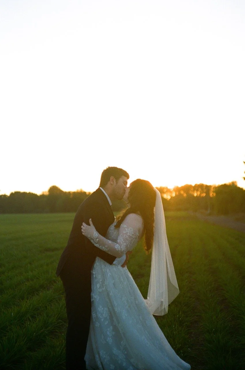 Carley and Preston embracing in the field at sunset, shot on film