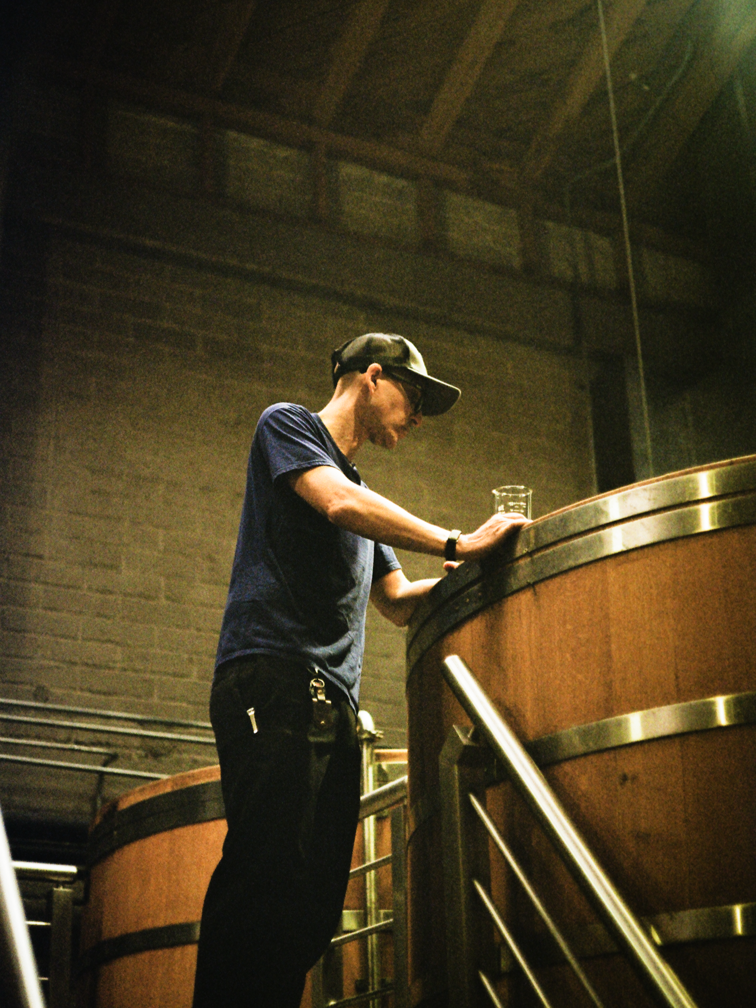 A distiller checking a barrel from the platform, shot on film