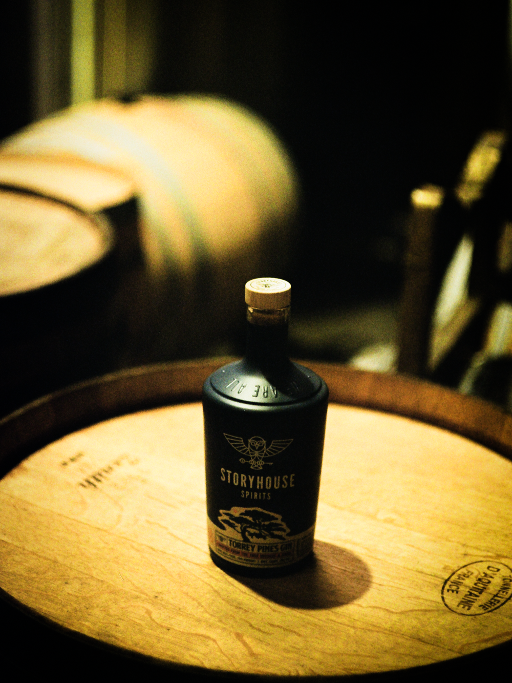 A Storyhouse bottle on a sunlit barrel top, shot on film