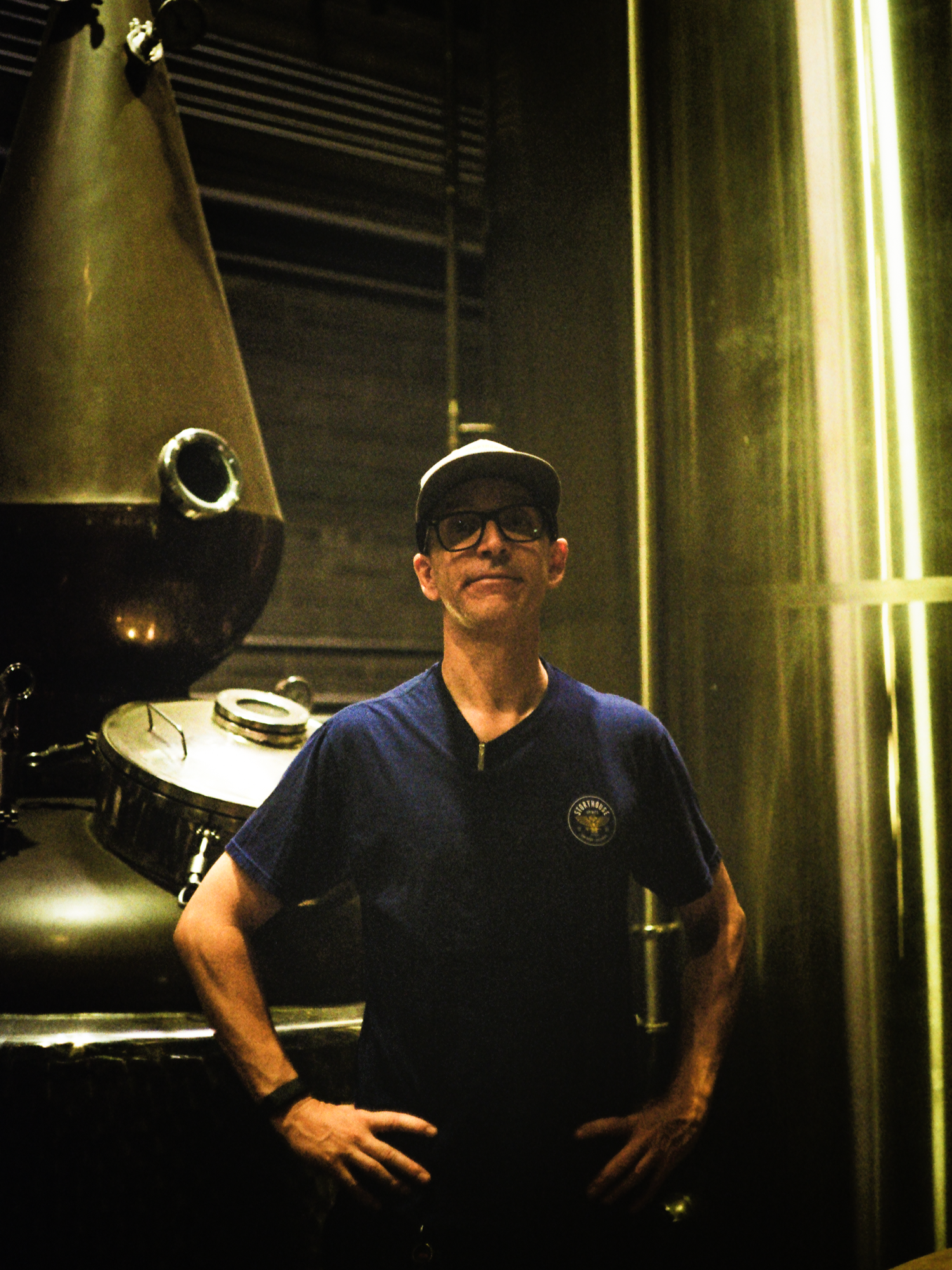 Eric smiling in front of the copper still at Storyhouse Spirits, shot on film