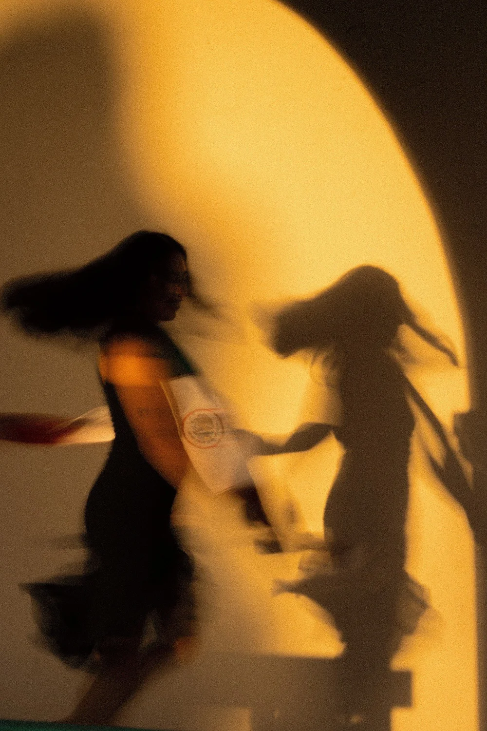 Magaly and her shadow in motion against an arched wall