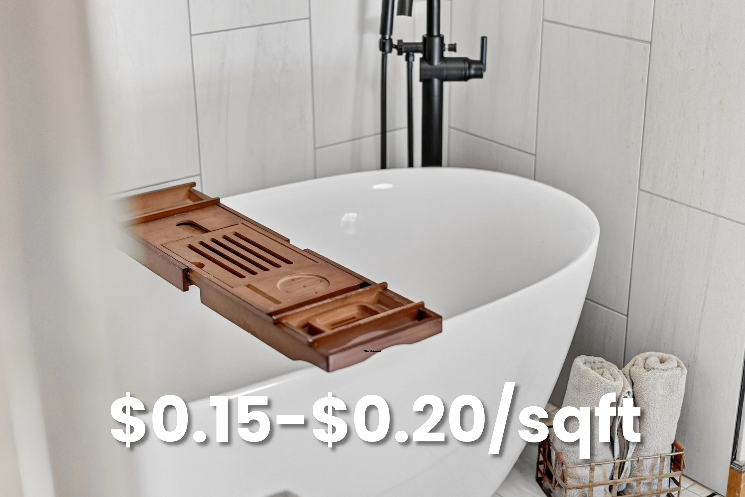 A white bathtub with a wooden bath tray, on a bathroom with gray tiled walls, a towel basket with beige towels, and a towel on the floor. The image contains text indicating a sale price between $0.15 and $0.20 per square foot.